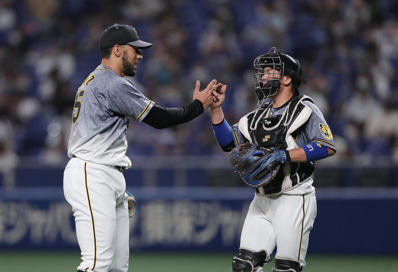 中日対阪神　中日に勝利しタッチを交わす阪神スアレス（左）と梅野（撮影・前田充）