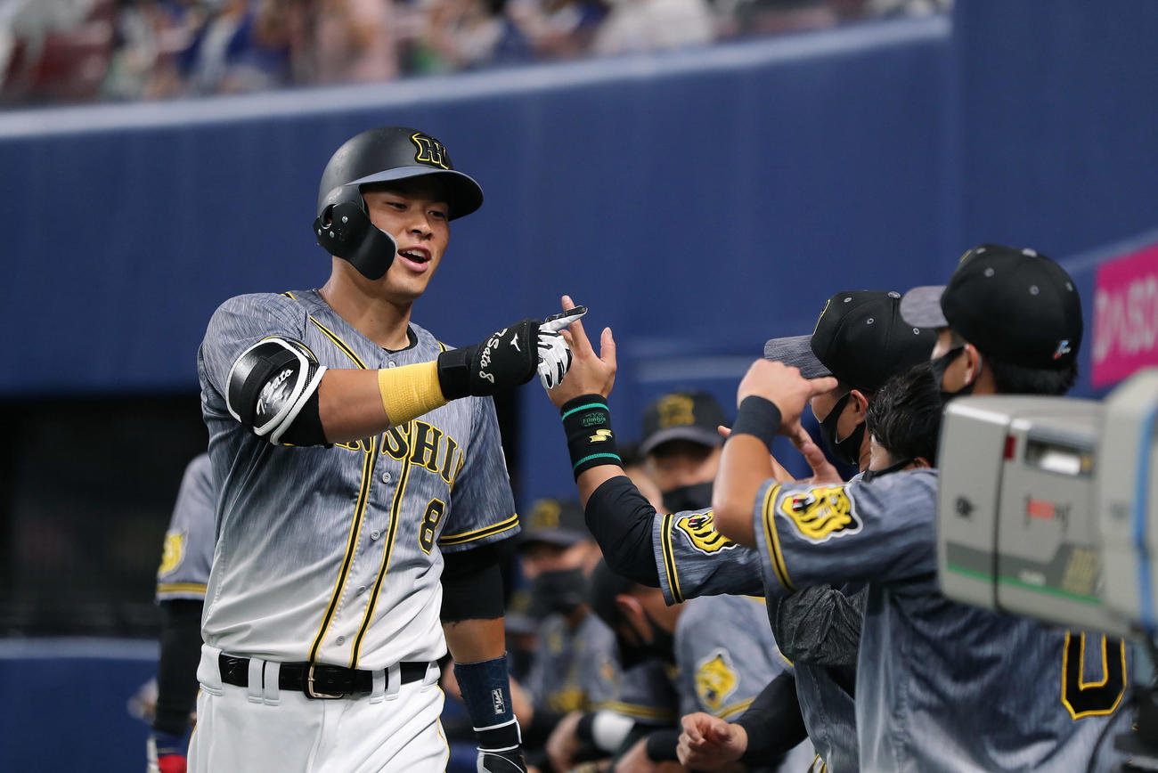 中日対阪神　6回表阪神1死、中越え本塁打を放ちナインに迎えられ笑顔を見せる佐藤輝（撮影・前田充）
