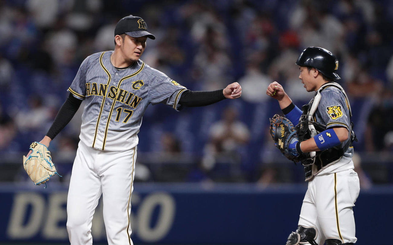 中日対阪神　中日に勝利しグータッチを交わす阪神岩貞（左）と梅野（撮影・前田充）