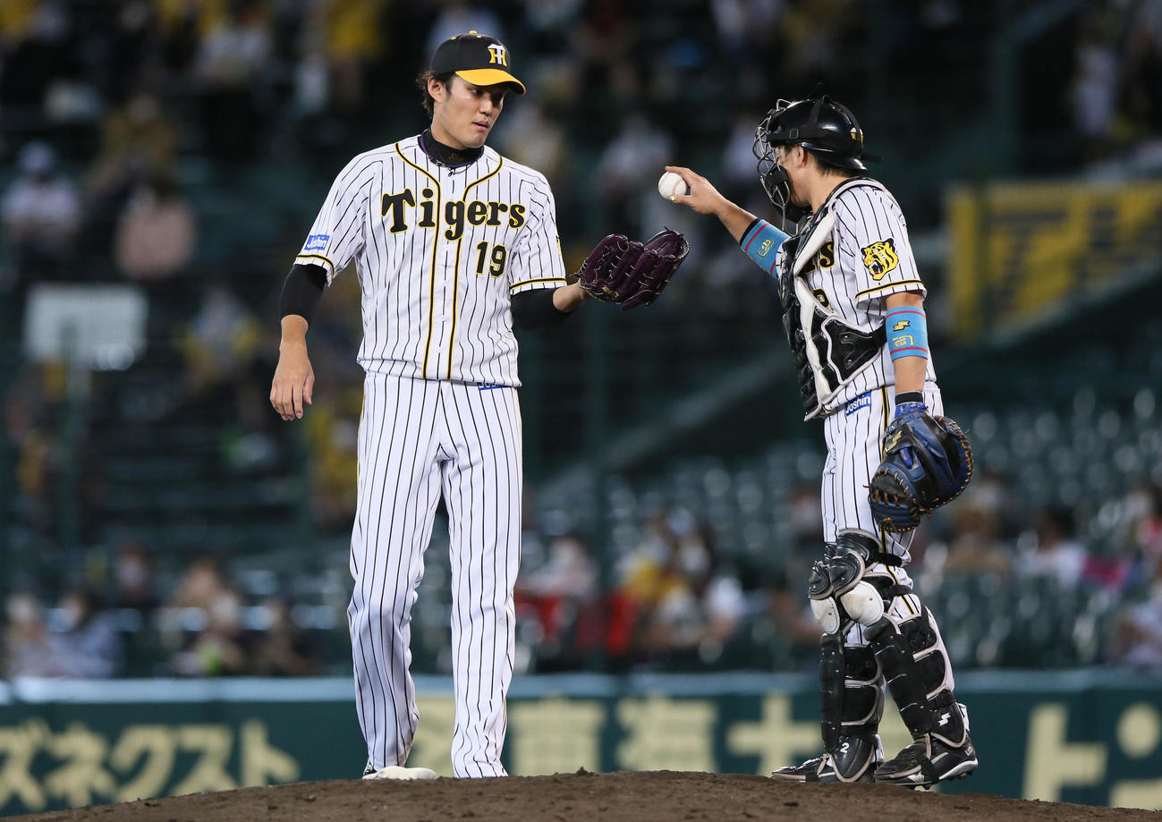 阪神対DeNA 9回に登板の藤浪（左）にボールを渡す梅野（撮影・上山淳一）