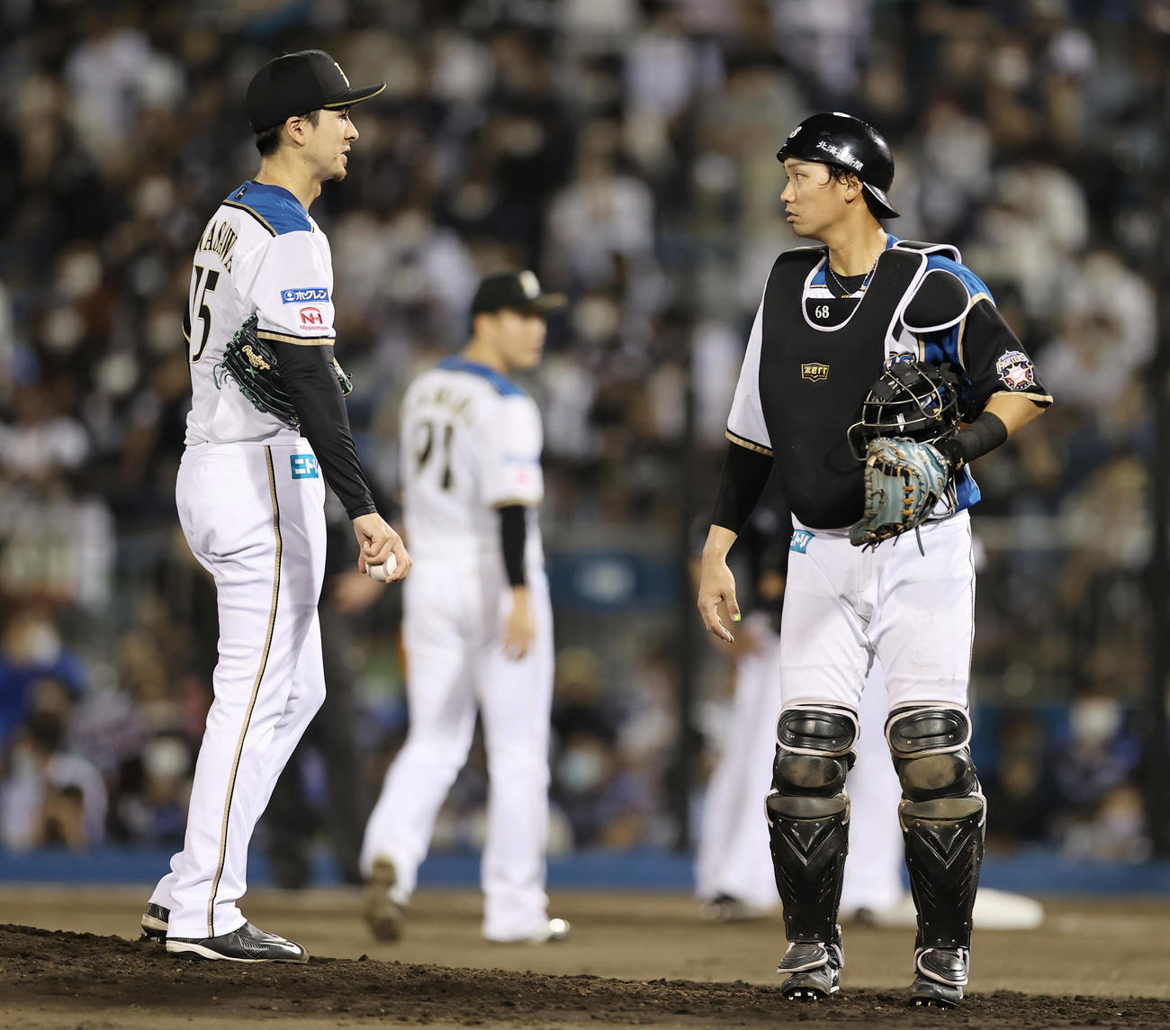 日本ハム対ロッテ　5回表ロッテ1死一、三塁、角中に適時打を許し渋い表情で言葉を交わす上沢（左）と石川（撮影・垰建太）