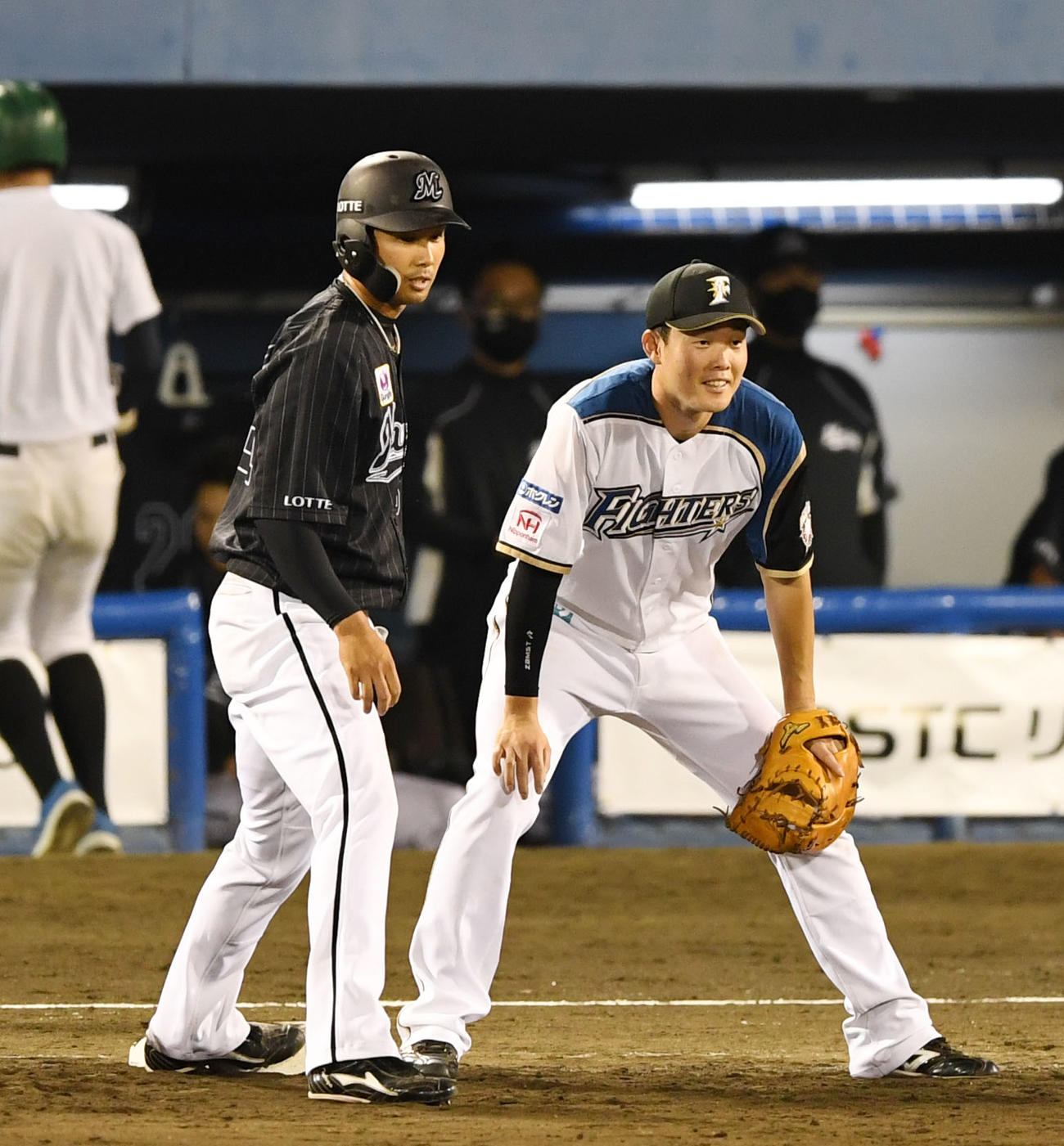 日本ハム対ロッテ　9回表ロッテ無死一塁、塁上で軽く会話を交わす兄のロッテ高浜卓也（左）と弟の日本ハム高浜祐仁（撮影・横山健太）