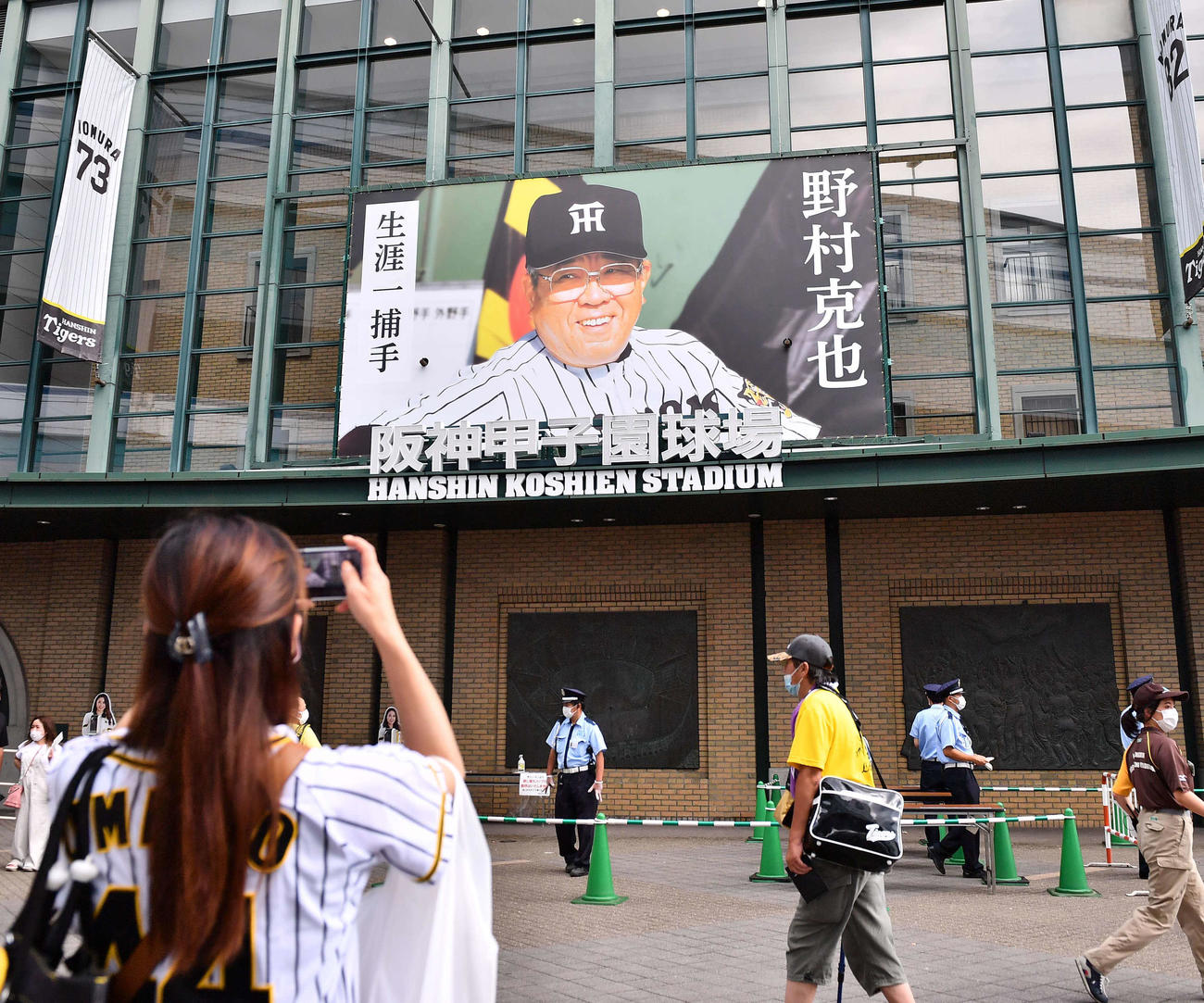 阪神対ヤクルト　野村克也氏の写真をスマホで撮影するファン（撮影・上田博志）