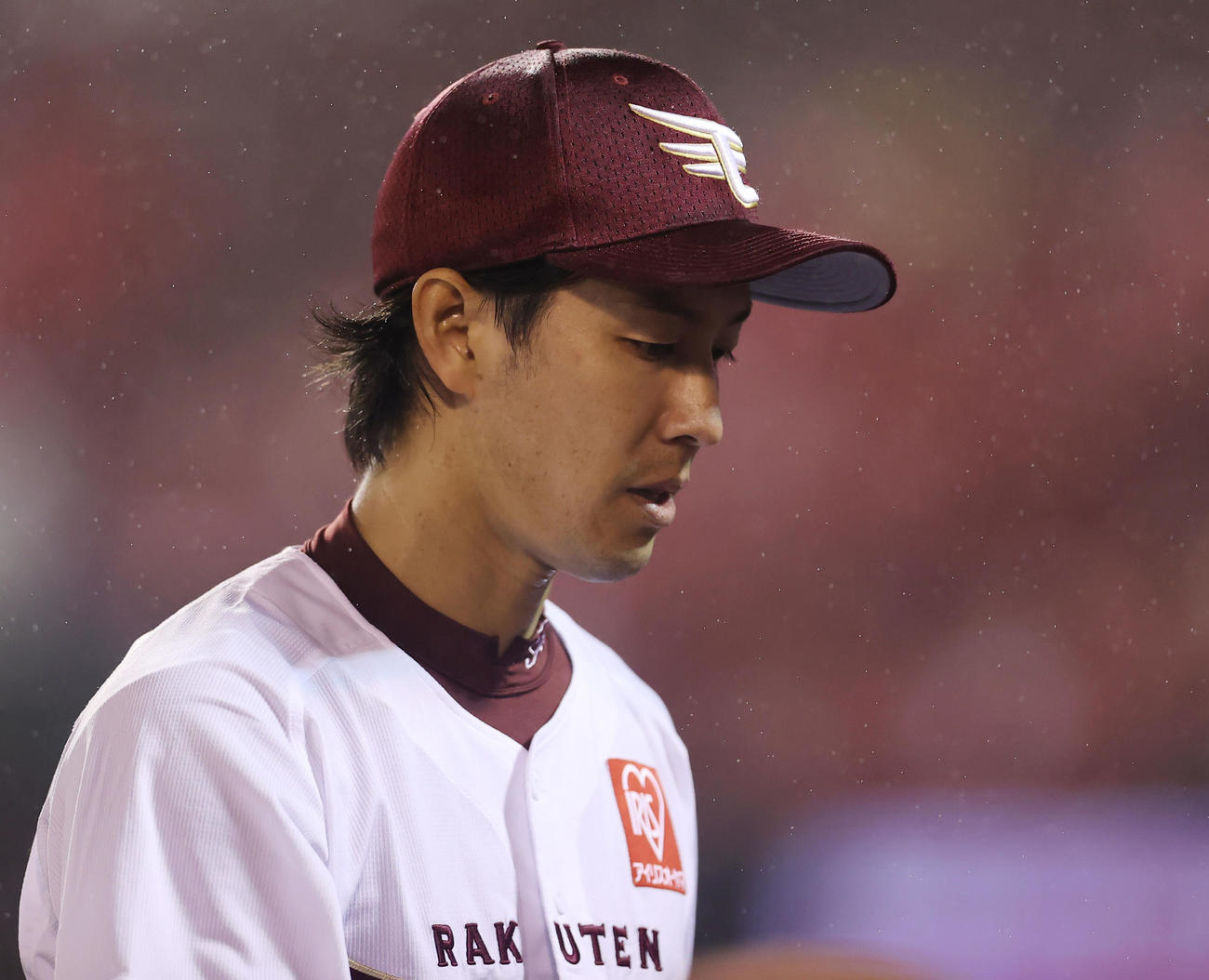 楽天対日本ハム　味方打線の援護なく7回表の登板を終え雨に打たれながら引き揚げる楽天先発の岸（撮影・垰建太）