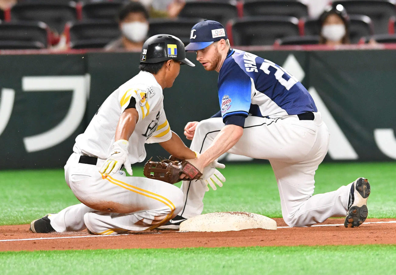 ソフトバンク対西武　9回裏ソフトバンク1死一塁、中村晃の左前安打で佐藤直（左）は三塁を狙うも、スライディング後にベースから離れてしまいタッチアウトとなる。右はスパンジェンバーグ（撮影・岩下翔太）