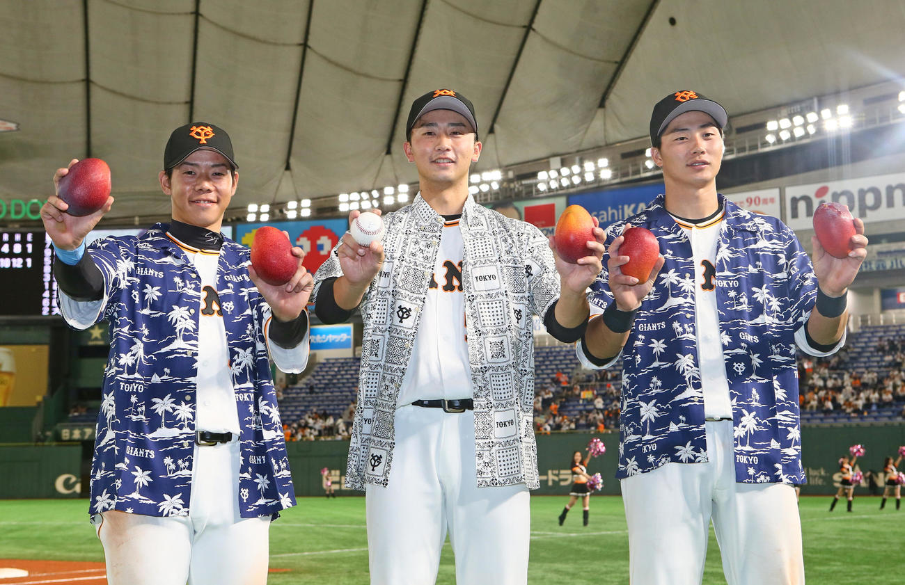 巨人対広島　巨人の、左から松原、直江、広岡は宮崎デーにちなみハワイアンシャツ姿、マンゴーを手に笑顔を見せる（撮影・足立雅史）