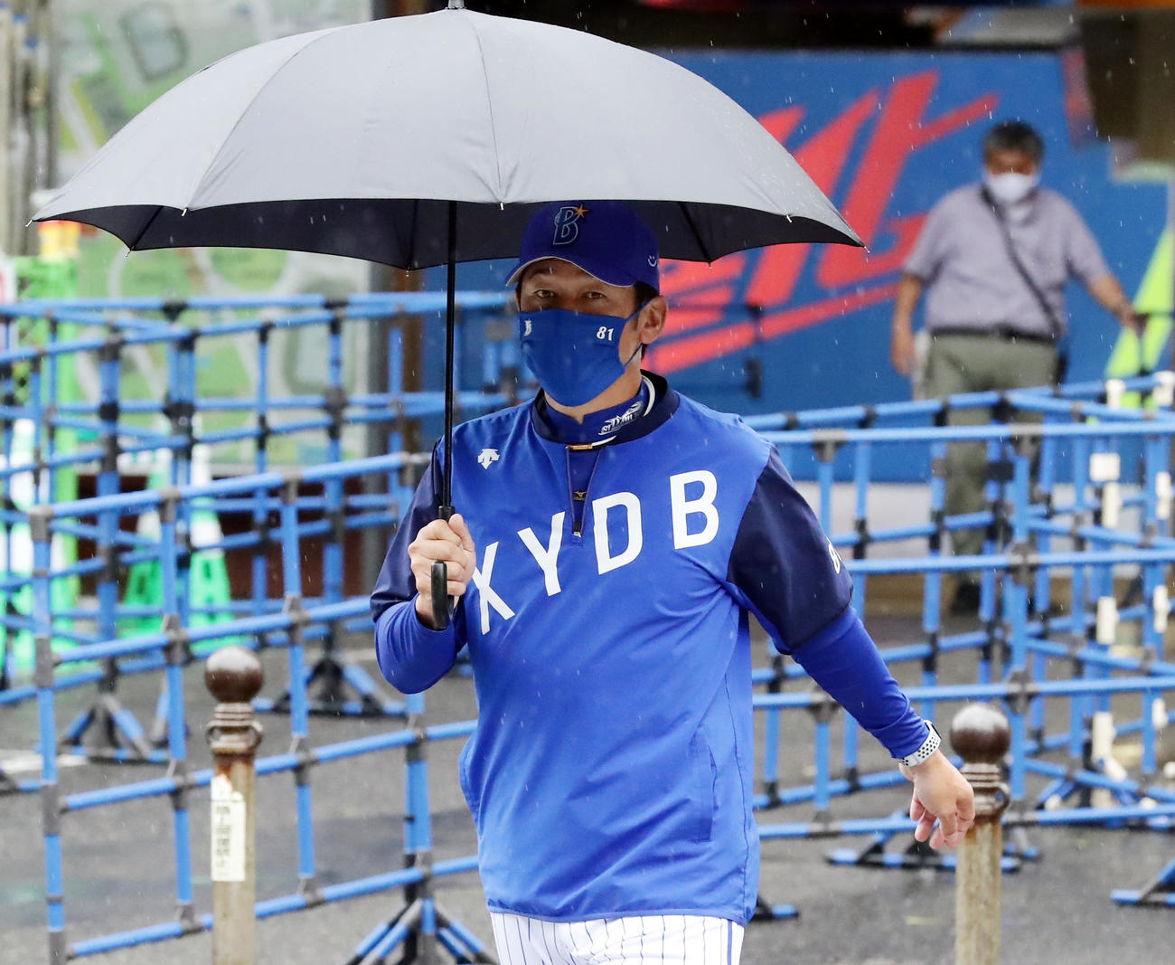 DeNA対巨人　雨天のため傘を差して室内練習場に向かうDeNA三浦監督（撮影・浅見桂子）