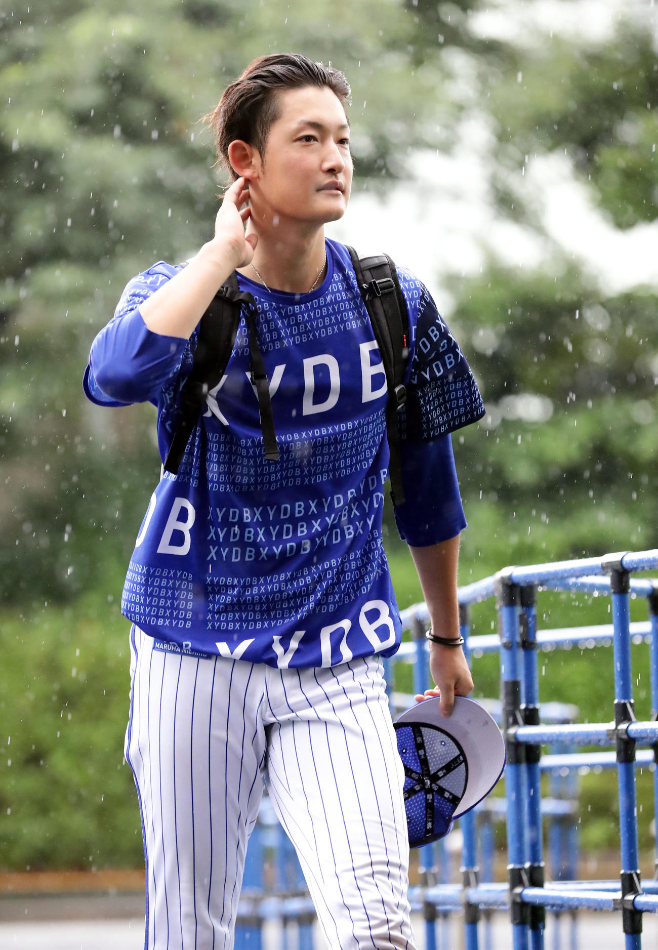 DeNA対巨人　雨の中、室内練習場から球場に向かうDeNA阪口（撮影・浅見桂子）