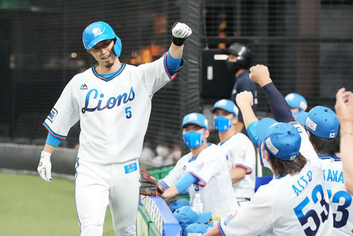 西武対オリックス　3回裏西武2死、左中間にソロ本塁打を放った外崎はベンチ前で左手を上げる（撮影・鈴木みどり）
