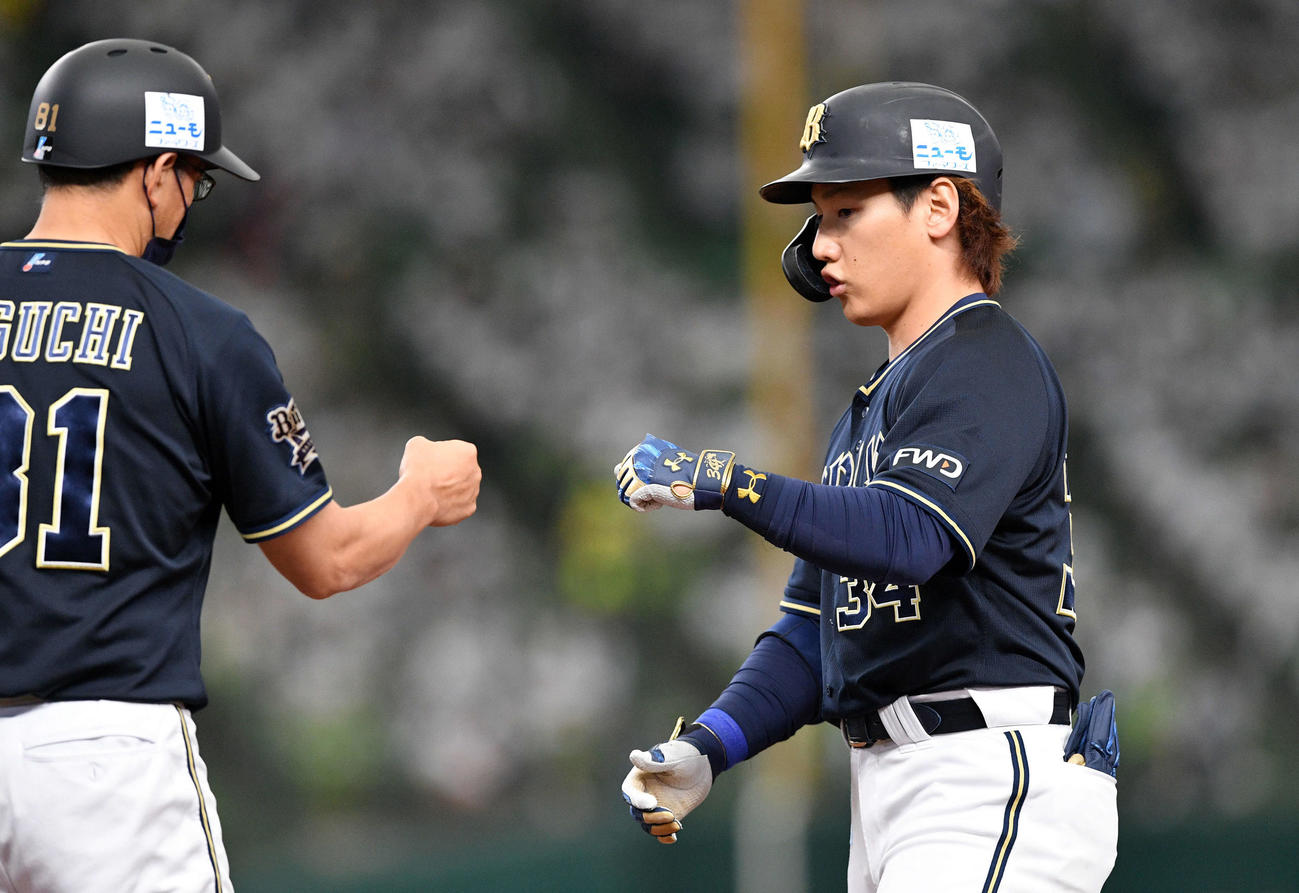 西武対オリックス　5回表オリックス2死一、三塁、勝ち越しの左前適時打を放った吉田正（右）は田口コーチとタッチを交わす（撮影・滝沢徹郎）