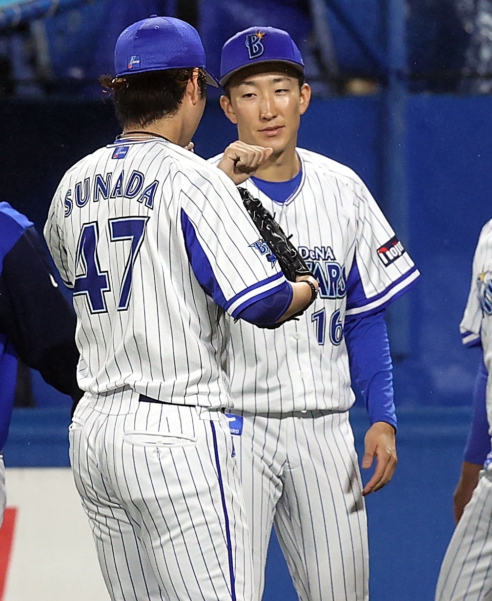 DeNA対巨人　6回表を抑えた砂田（手前）を迎える大貫（撮影・狩俣裕三）