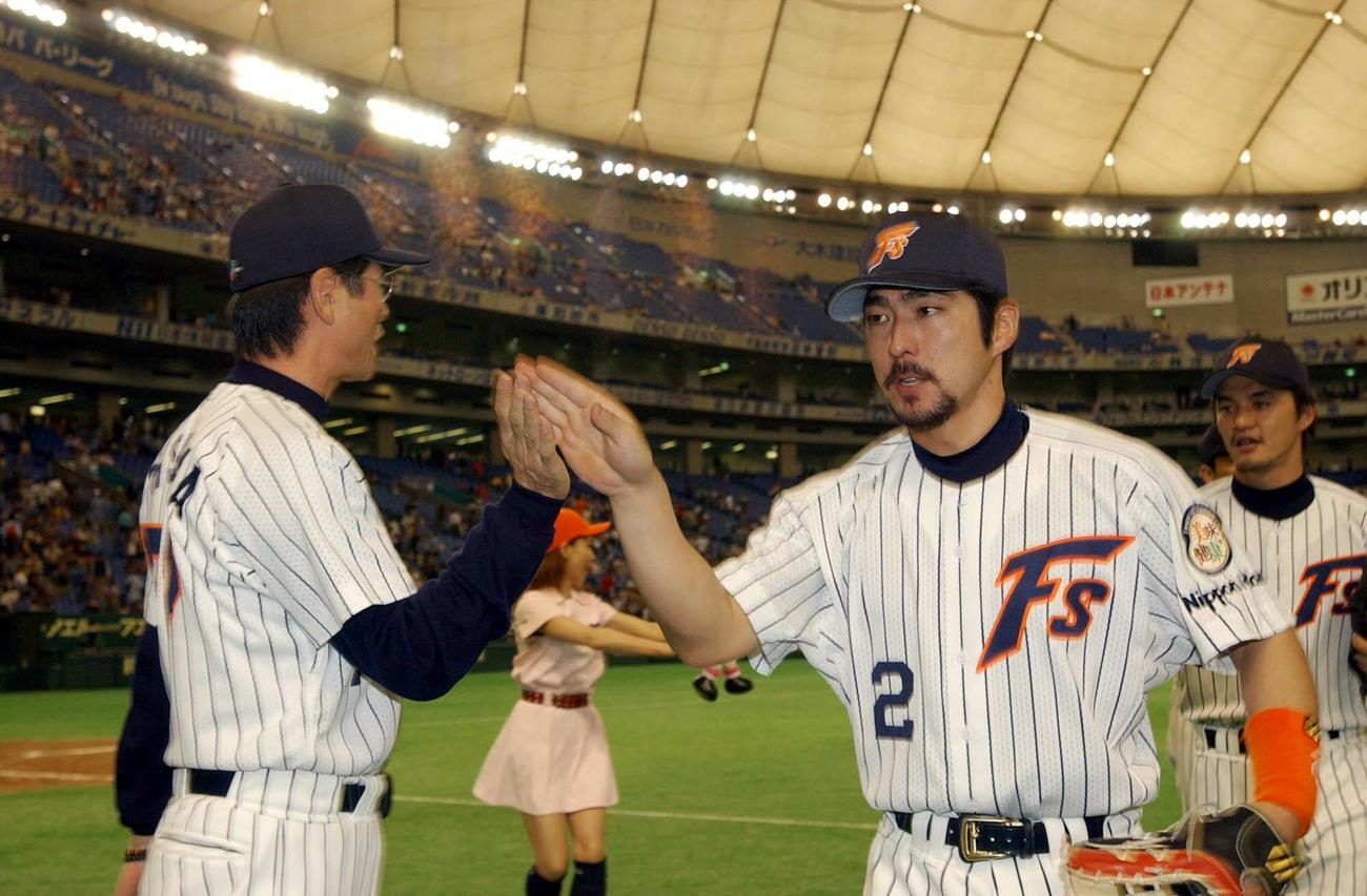 日本ハム対ダイエー　通算100号本塁打を放った小笠原道大（右）は、大島康徳監督の出迎えを受ける（02年05月04日撮影）