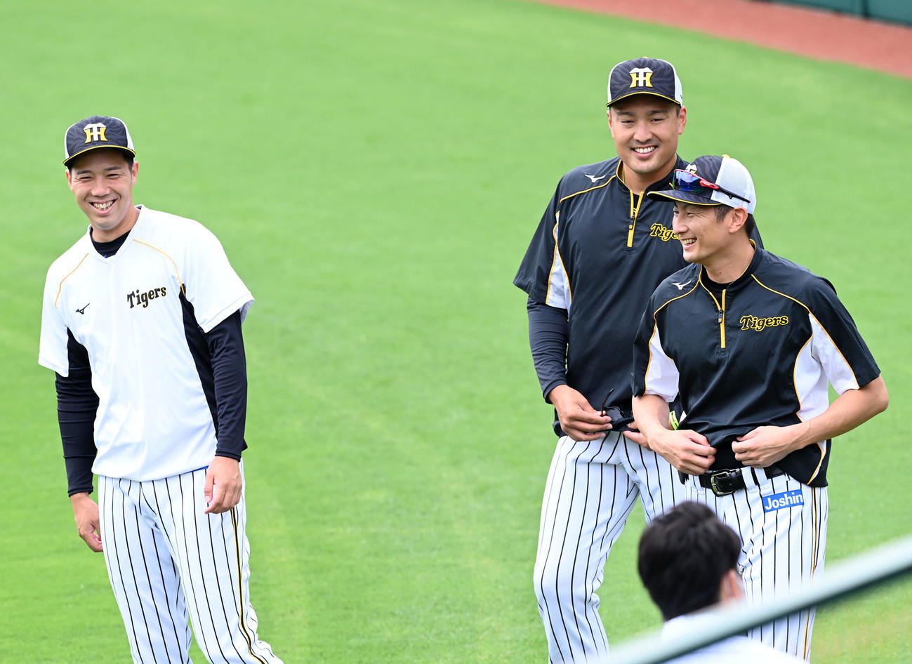 阪神の練習に合流した二保（右）は青柳（左）、秋山と笑顔で話す（撮影・前岡正明）