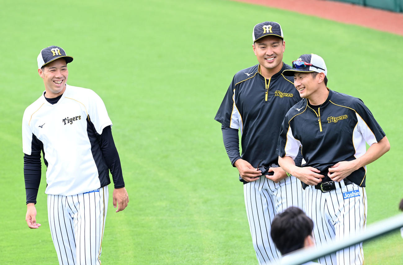 阪神の練習に合流した二保（右）は青柳（左）、秋山と笑顔で話す（撮影・前岡正明）