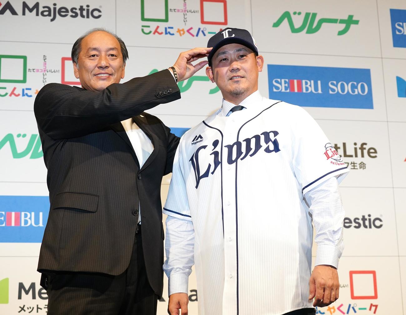 14年ぶりに西武に復帰する松坂は、入団会見でユニホームに袖を通し、渡辺GM（左）と記念写真に納まる（2019年12月11日）