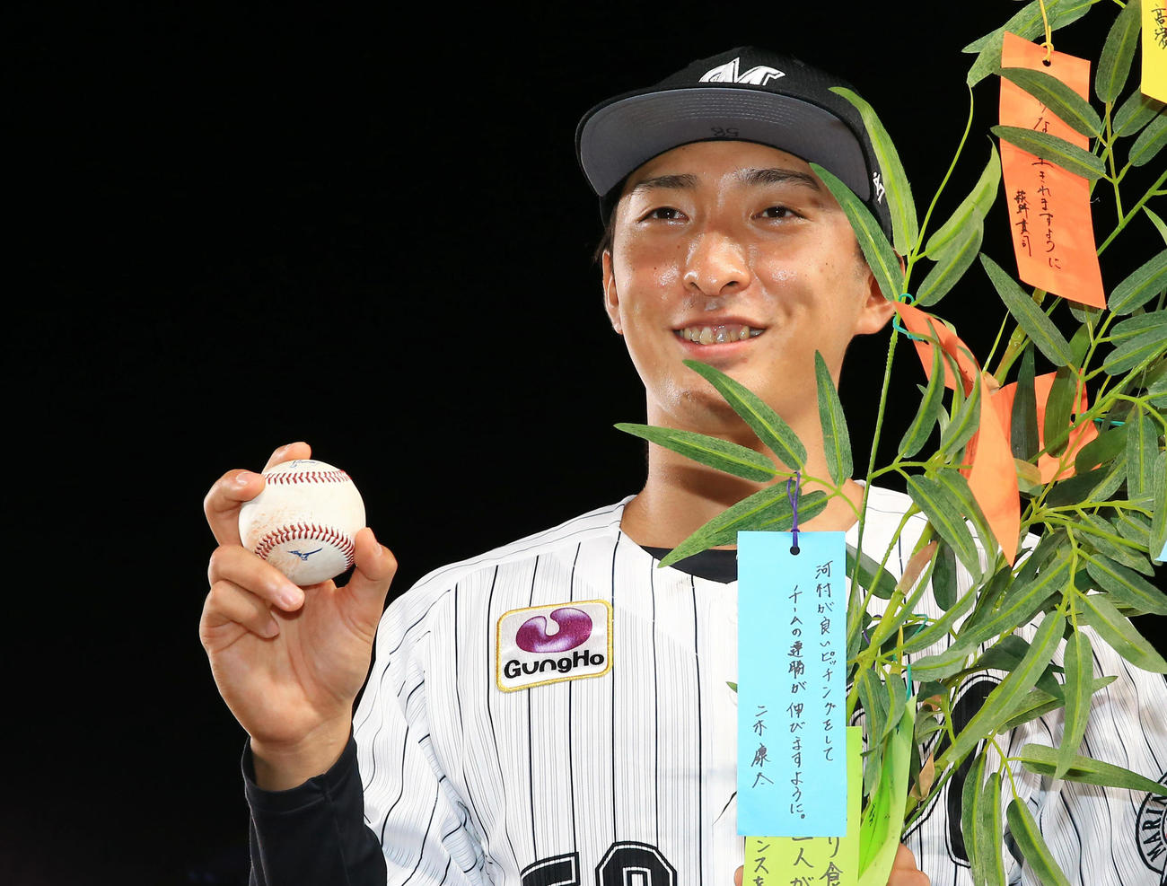 ロッテ対ソフトバンク　プロ初勝利を挙げ勝利球を手に笑顔で写真に納まるロッテ河村の笑顔の下には前日勝利投手の二木の「河村が良いピッチングをしてチームの連勝が伸びますように」と書かれた短冊が飾られている（撮影・垰建太）