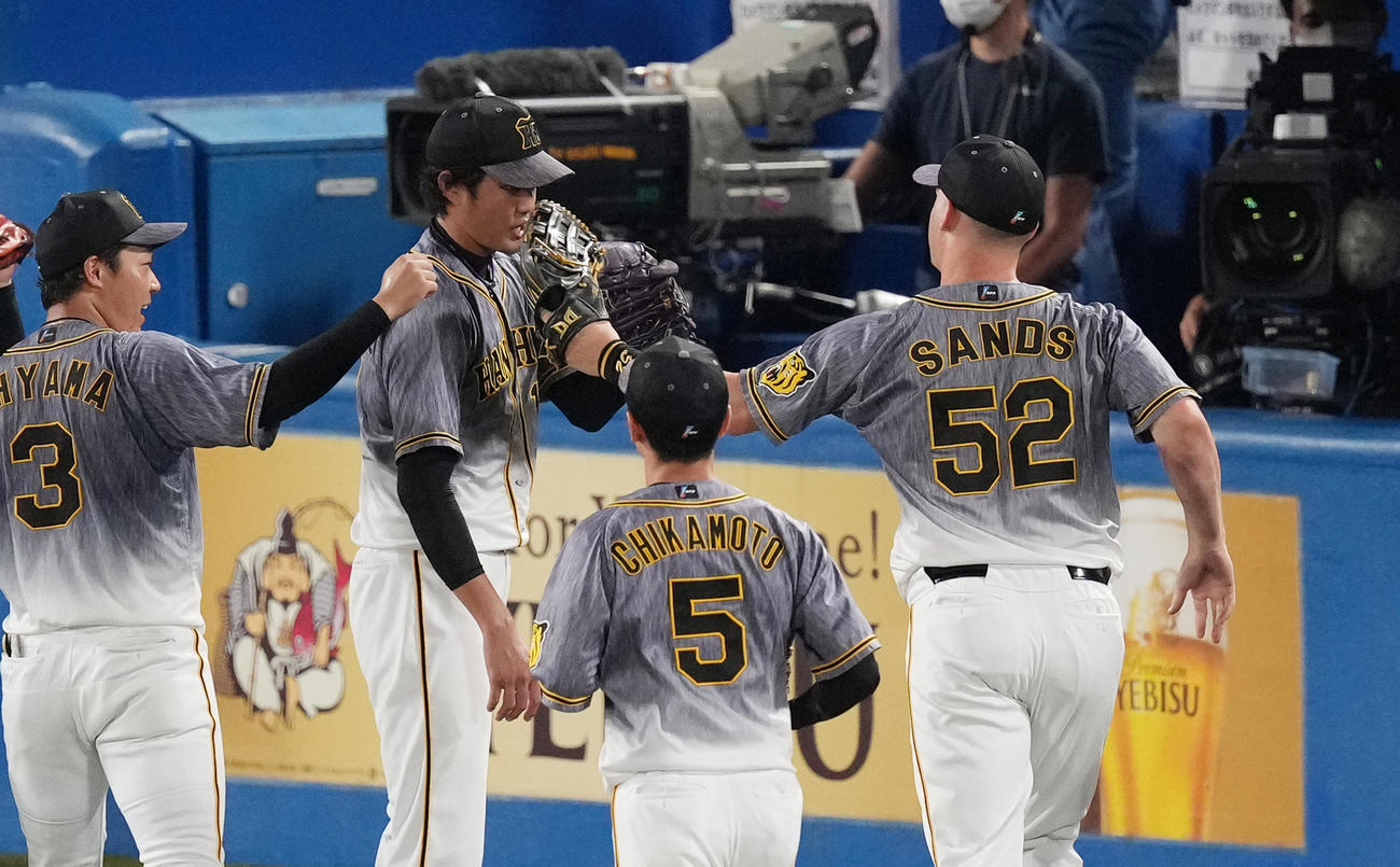 ヤクルト対阪神　6回裏ヤクルト2死一、二塁、川端の打球を好捕したサンズ（右）をタッチで迎える藤浪（左から2人目）（撮影・菅敏）