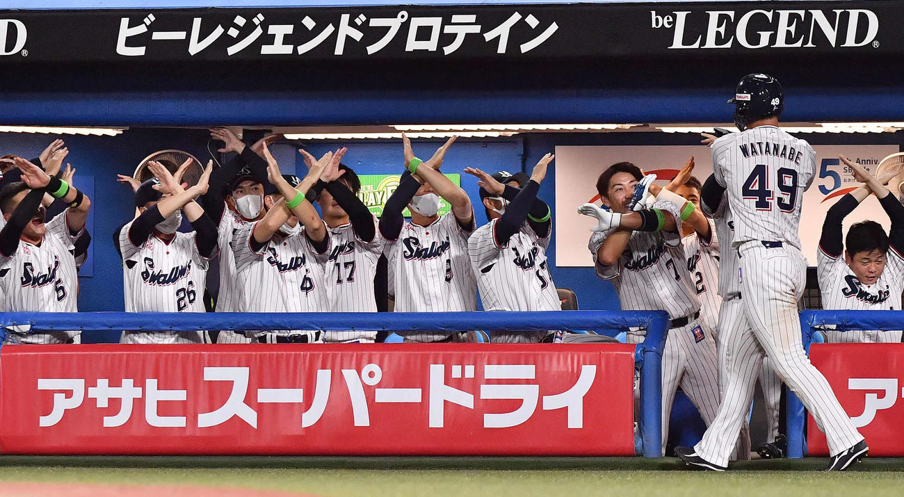 ヤクルト対阪神　8回裏ヤクルト1死一、三塁、山田の左犠飛で生還しXポーズのナインの出迎えを受ける渡辺（撮影・上田博志）