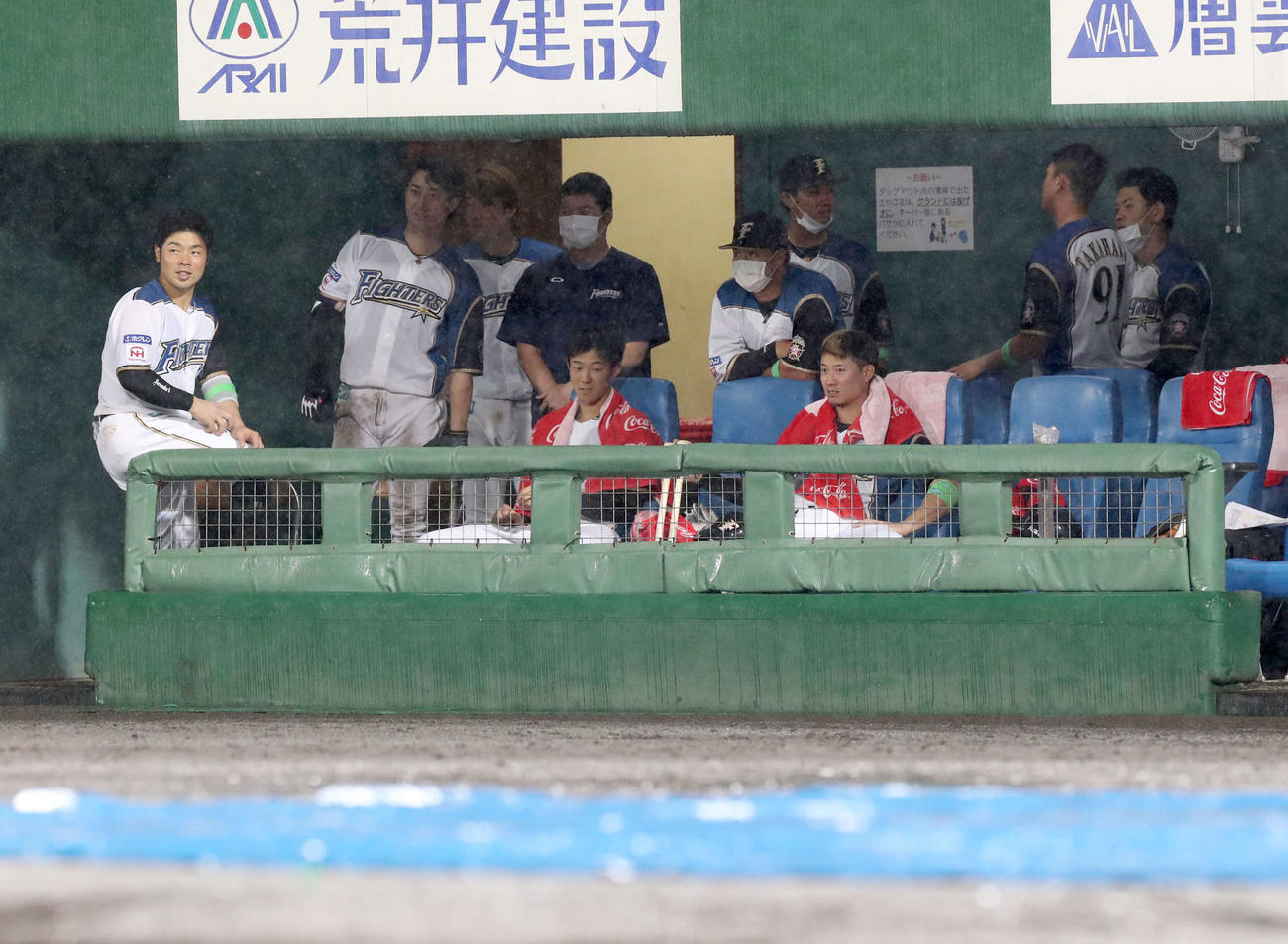 日本ハム対西武　雨のため試合が一時中断しベンチで待機する日本ハムナイン（撮影・佐藤翔太）