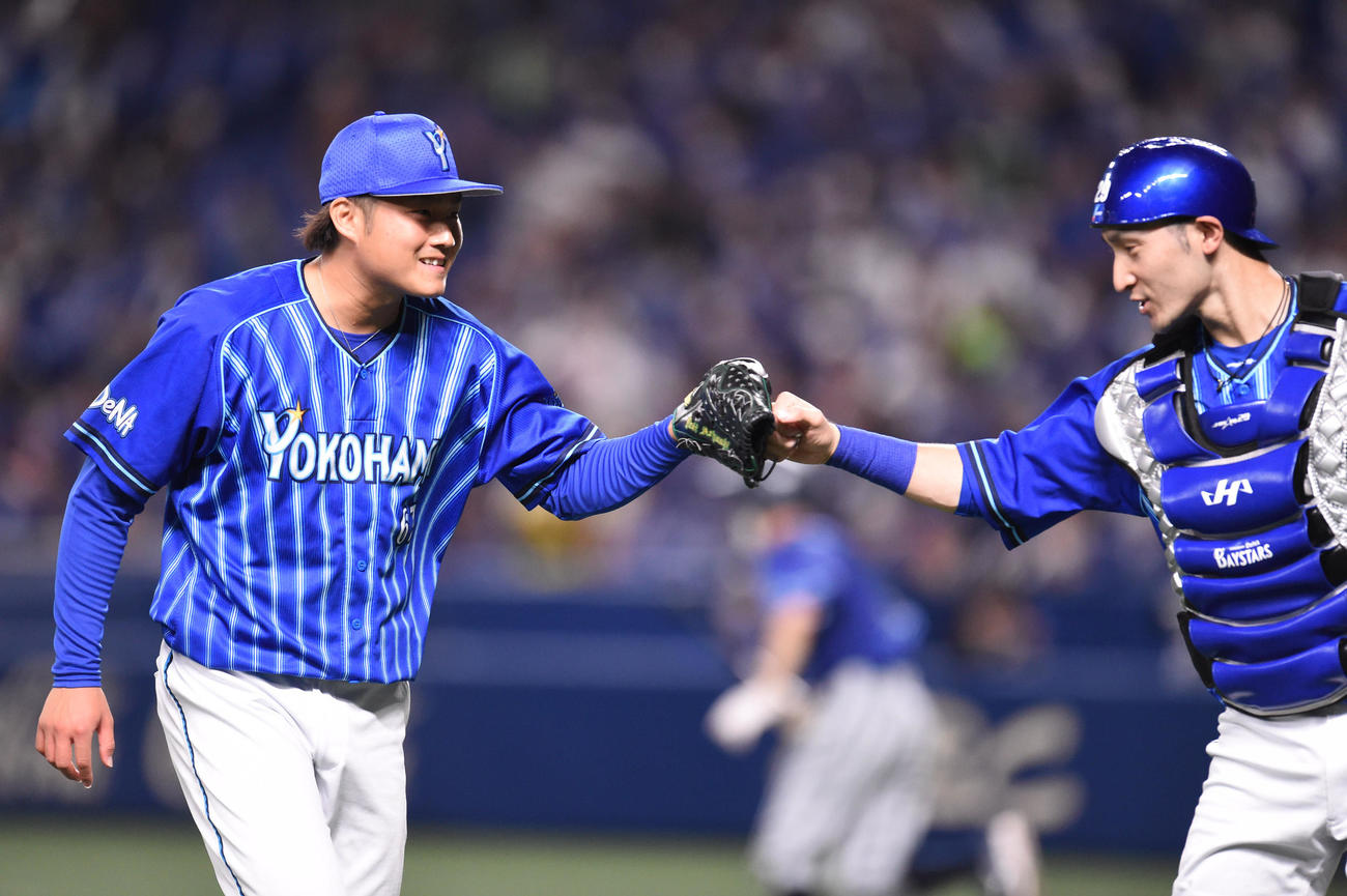 中日対DeNA 1回裏中日攻撃終了、伊藤光（右）とタッチを交わしベンチへ戻るDeNA先発の有吉（左）（撮影・森本幸一）