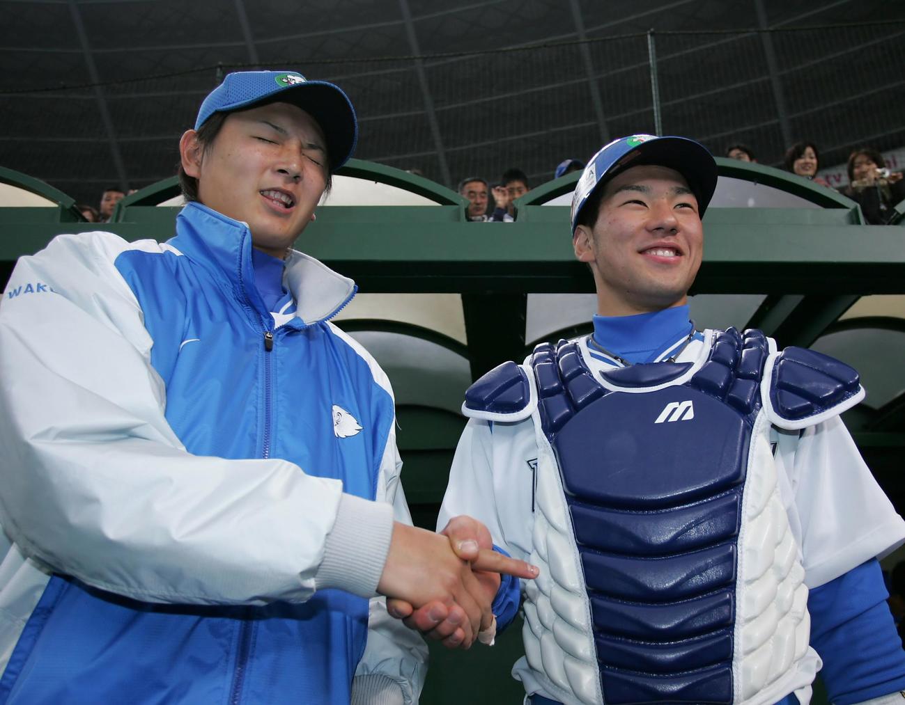 2006年3月26日、西武対オリックス　涌井秀章（左）は炭谷銀仁朗との握手で右手が痛み顔をゆがめた。2人の年齢を合わせても37歳というフレッシュコンビだった