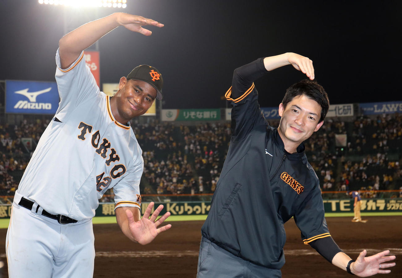 阪神対巨人　ヒーローインタビュー後、通訳といっしょに5勝目のCCポーズを決めるメルセデス（左）（撮影・狩俣裕三）