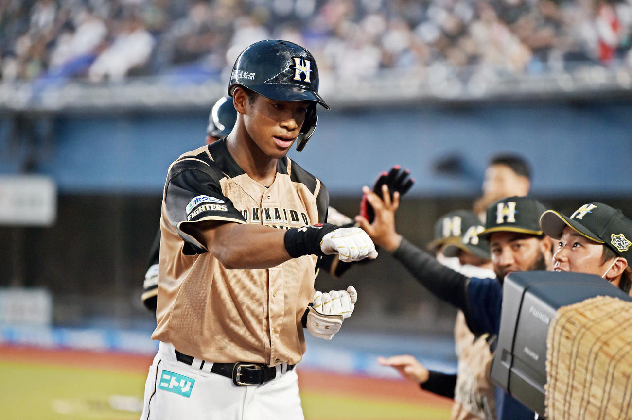 ロッテ対日本ハム　6回表日本ハム1死一塁、左中間へ一時勝ち越しの2点本塁打を放った万波（左）は生還しカメラにポーズを決める（撮影・滝沢徹郎）