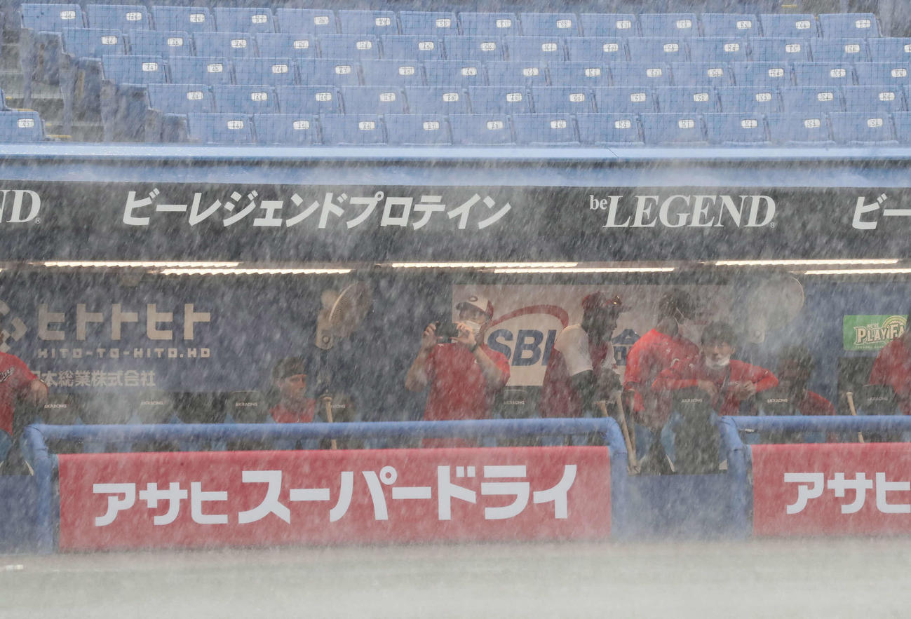 ゲリラ豪雨に襲われてベンチへ逃げ込んだ広島ナイン（撮影・丹羽敏通）