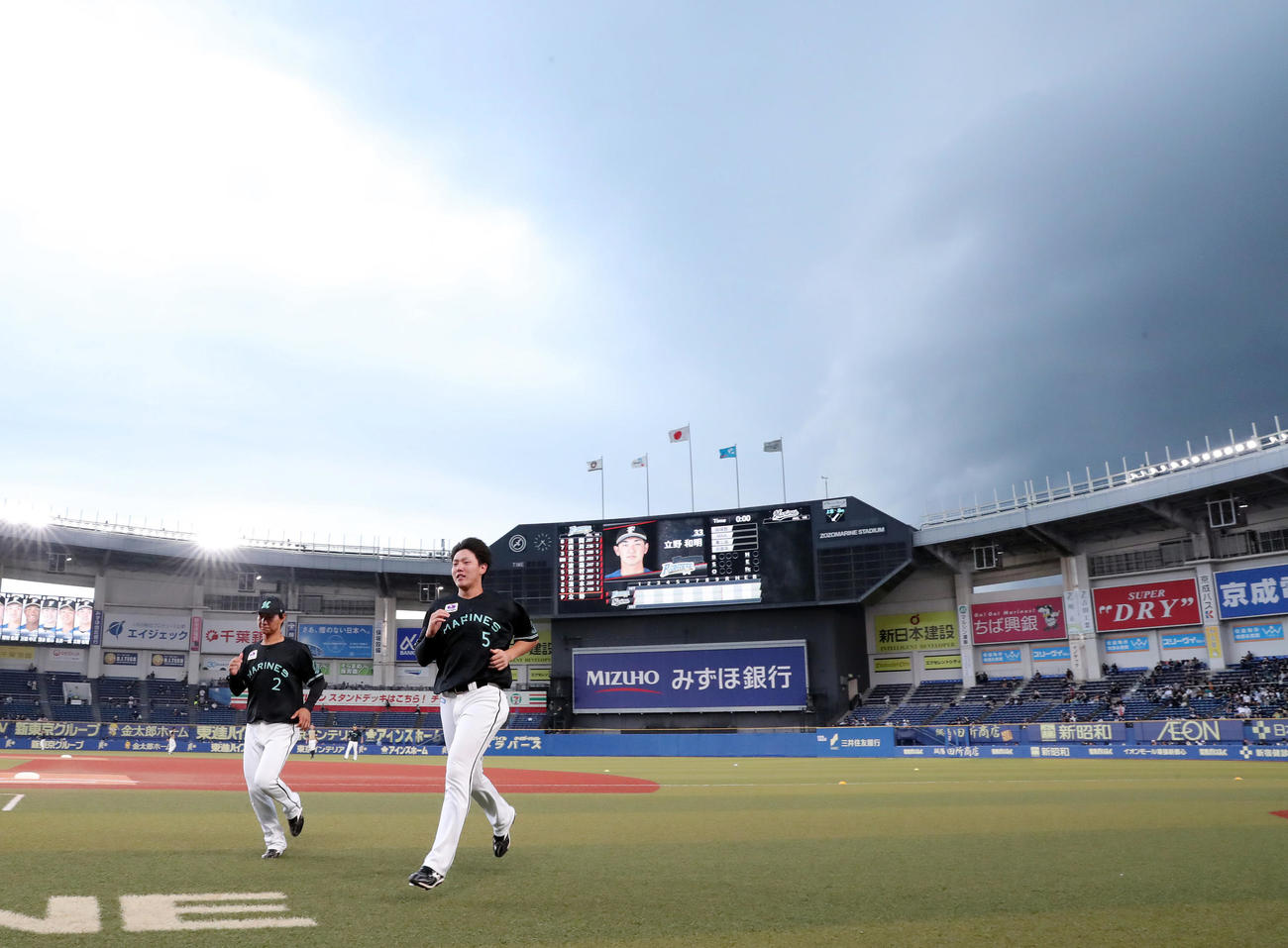 ロッテ対日本ハム　試合前、ロッテ藤原（左）と安田は一度グラウンドに出るも猛スピードで近づく分厚い雨雲に気づきベンチに引き揚げる（撮影・垰建太）