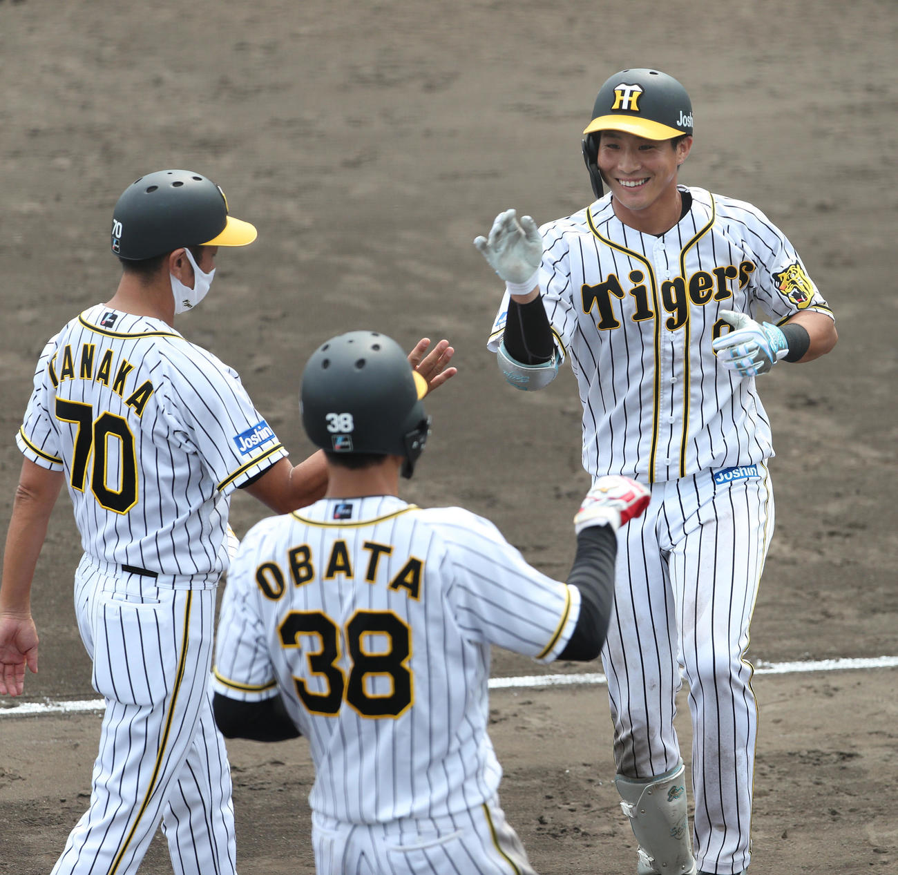 2軍広島戦で木浪はサヨナラ打を放ち、田中コーチ（左）、小幡（中央）にタッチで迎えられる（代表撮影）