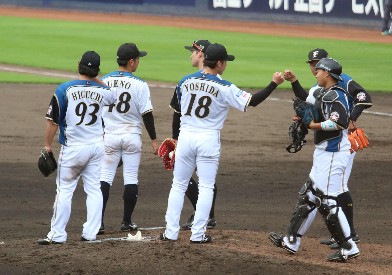 日本ハム対DeNA　プロ初セーブを挙げた日本ハム吉田（中央）は捕手田宮（右）とグータッチ（撮影・木下大輔）