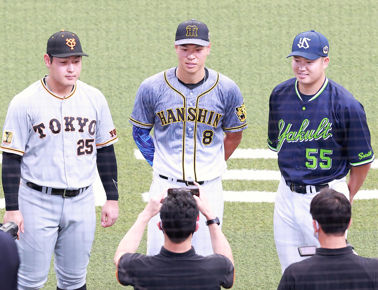 グラウンドで取材を受け記念撮影する、左から岡本和、佐藤輝、村上（撮影・浅見桂子）