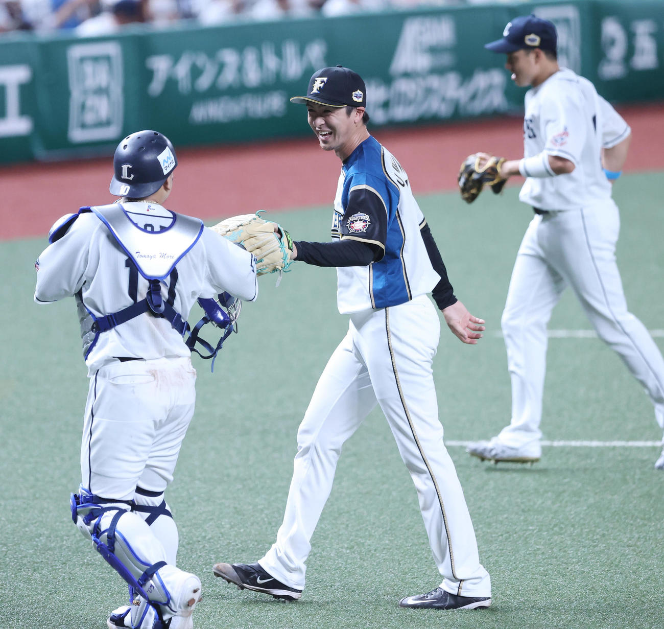 全パ対全セ　5回表の登板を終えた全パ上沢（中央）は笑顔で森（左）とタッチを交わす（撮影・垰建太）