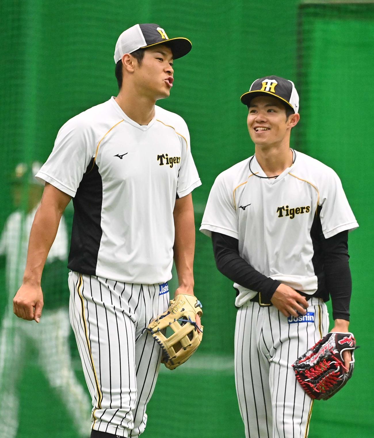 練習中、笑顔の阪神佐藤輝明（左）と中野拓夢（2021年7月14日撮影）