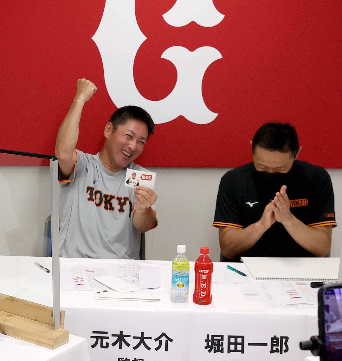 Gドラフト会議で当たりくじを引き、ガッツポーズを見せる元木ヘッドコーチ（左）。右は堀田マネジャー（球団提供）