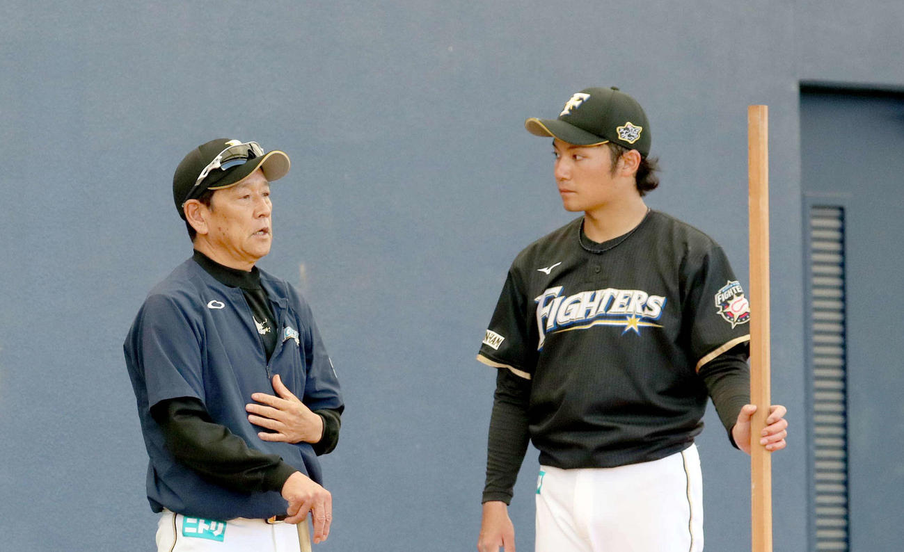 ブルペンでの投球を終え日本ハム栗山監督（左）と会話をする伊藤（2021年2月6日撮影）