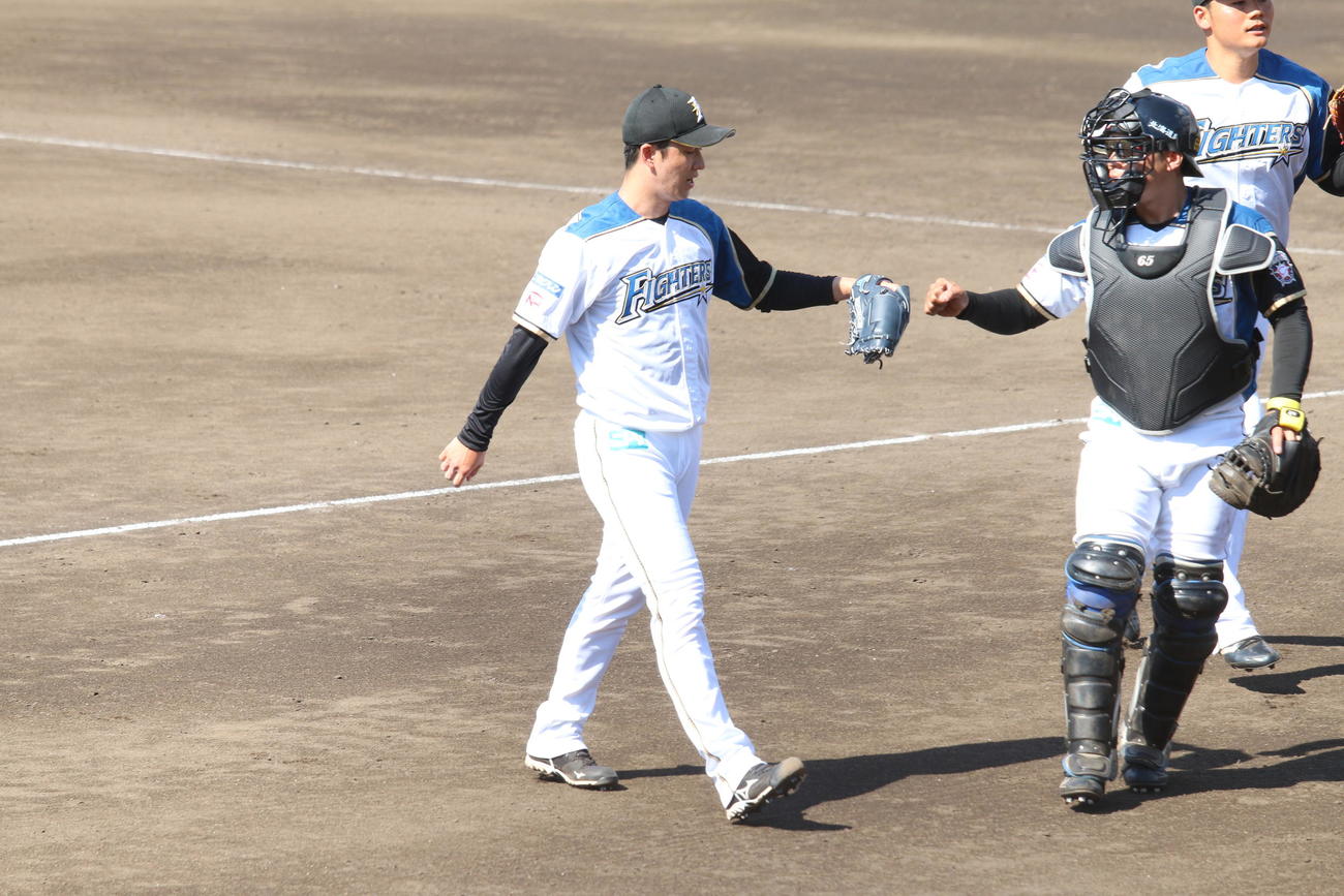 捕手梅林とグータッチする日本ハム斎藤（撮影・田中彩友美）
