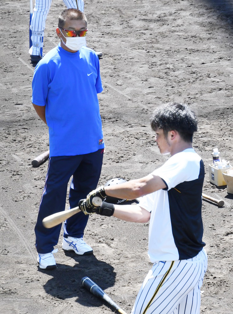 練習試合　阪神2軍対大和高田クラブ　試合前、阪神小野寺（右）の打撃練習を見守る大和高田クラブの佐々木恭介監督（代表撮影）