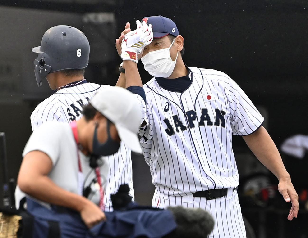 サヨナラ打を放った坂本（左）とタッチを交わす稲葉監督（共同）
