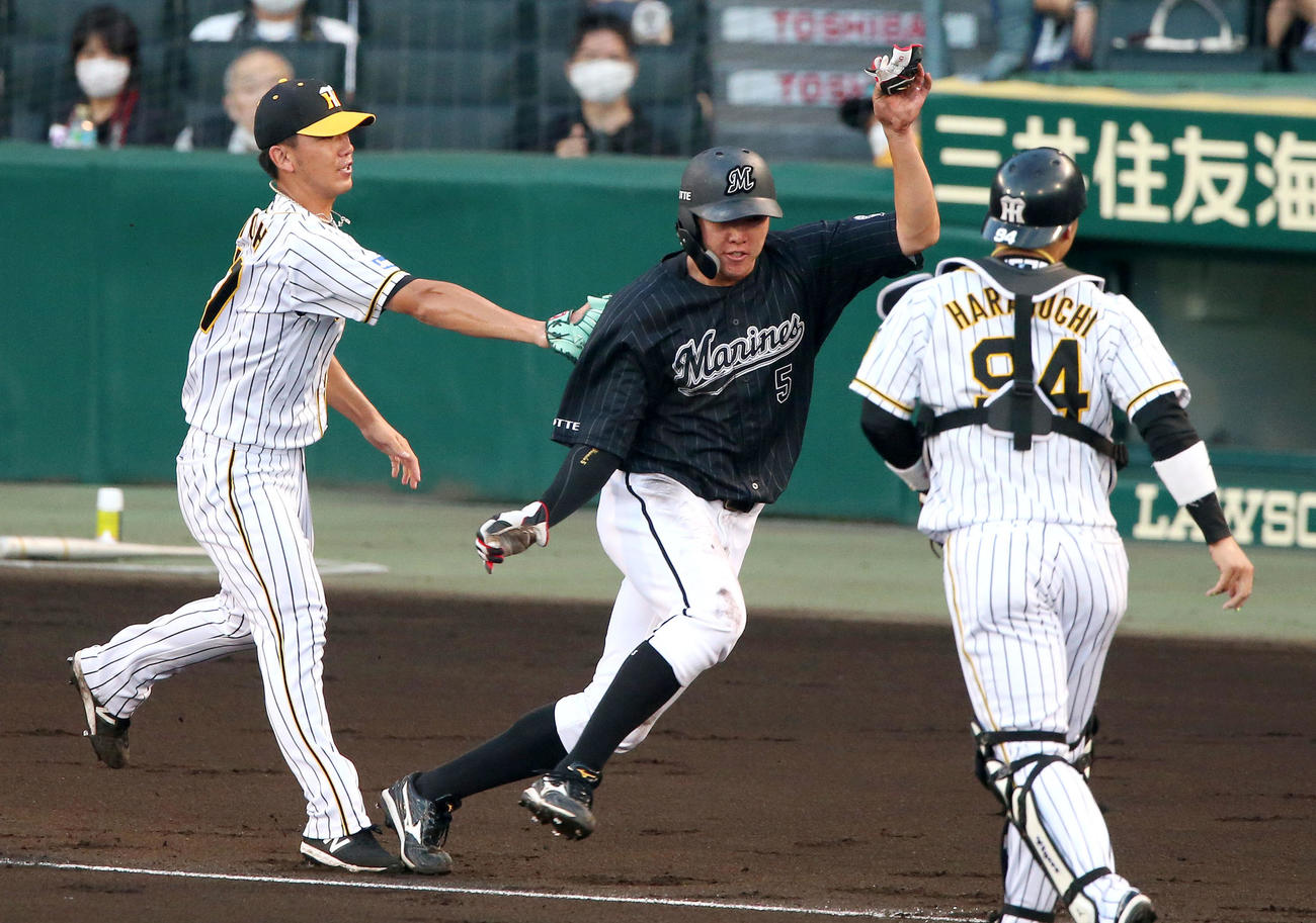 阪神対ロッテ　2回表ロッテ無死一、三塁、加藤の一ゴロで飛び出した三走安田を挟殺する（中央）を伊藤将（左）（撮影・上山淳一）