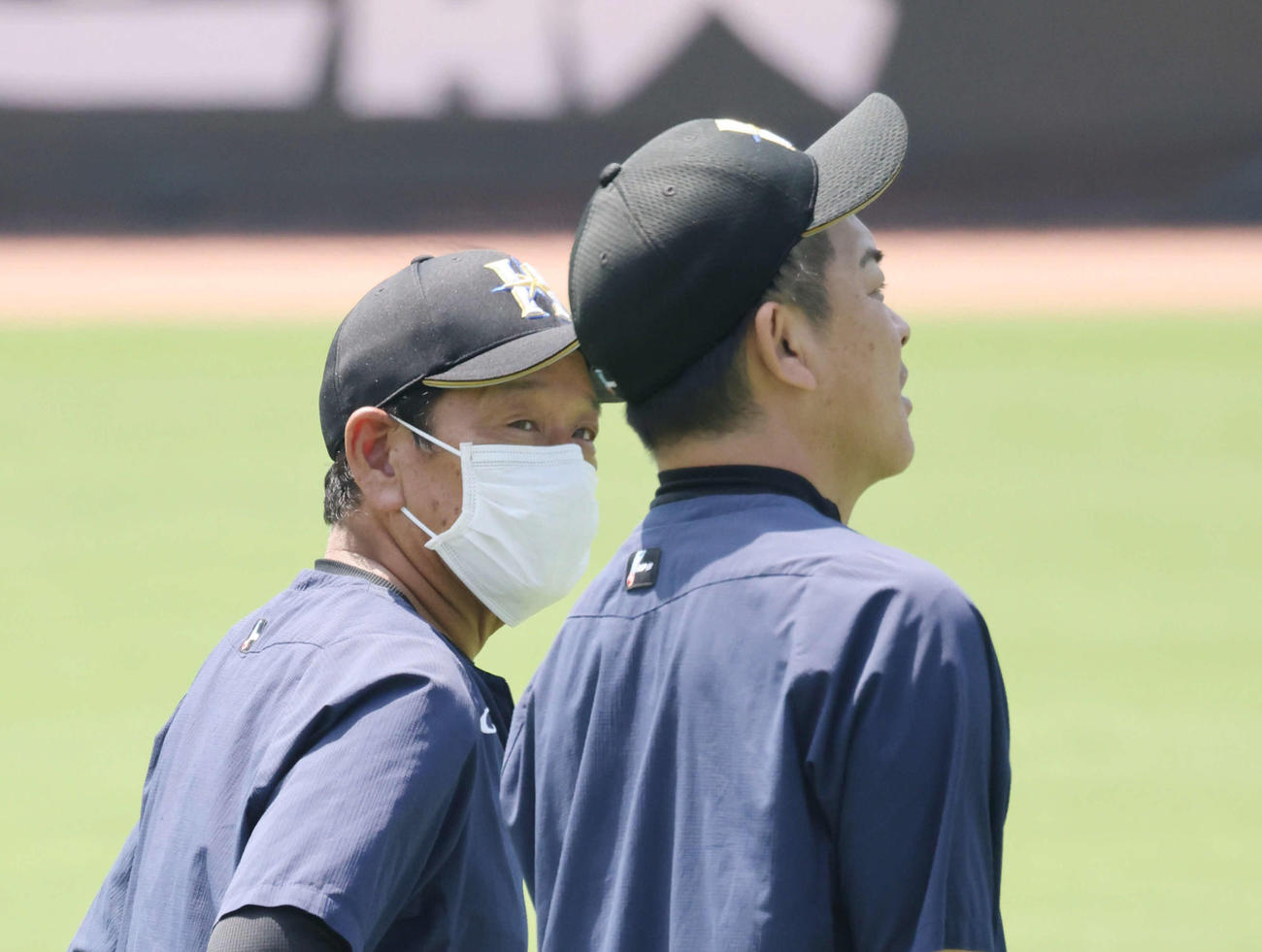 日本ハム練習　外野で練習を見守る栗山監督。右は厚沢投手コーチ（撮影・加藤孝規）