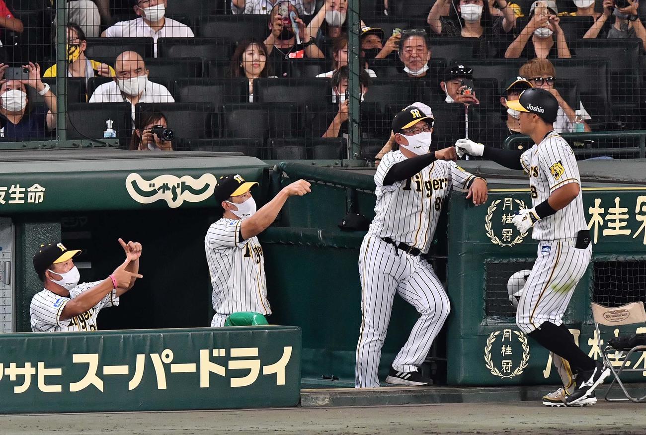阪神対西武　8回裏阪神1死、右越えに勝ち越しソロ本塁打を放った佐藤輝明（右）をグータッチで出迎える矢野燿大監督（左から2人目）（撮影・上田博志）