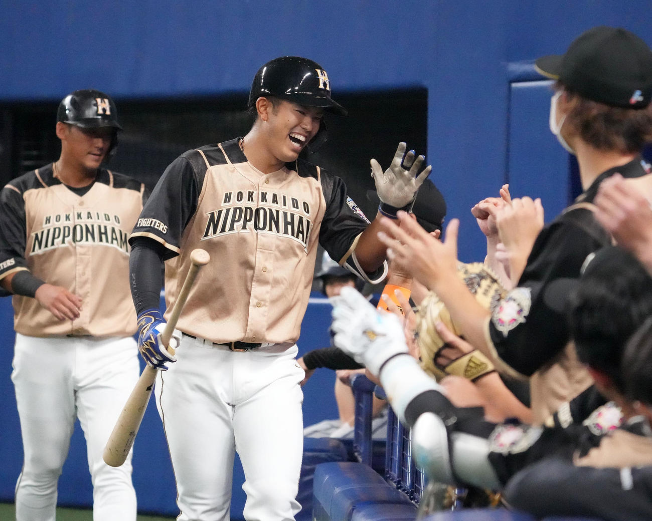 エキシビジョンマッチ中日対日本ハム　2回表日本ハム1死一塁、左越え2点本塁打を放ち明るい表情でナインとタッチを交わす今川（撮影・森本幸一）