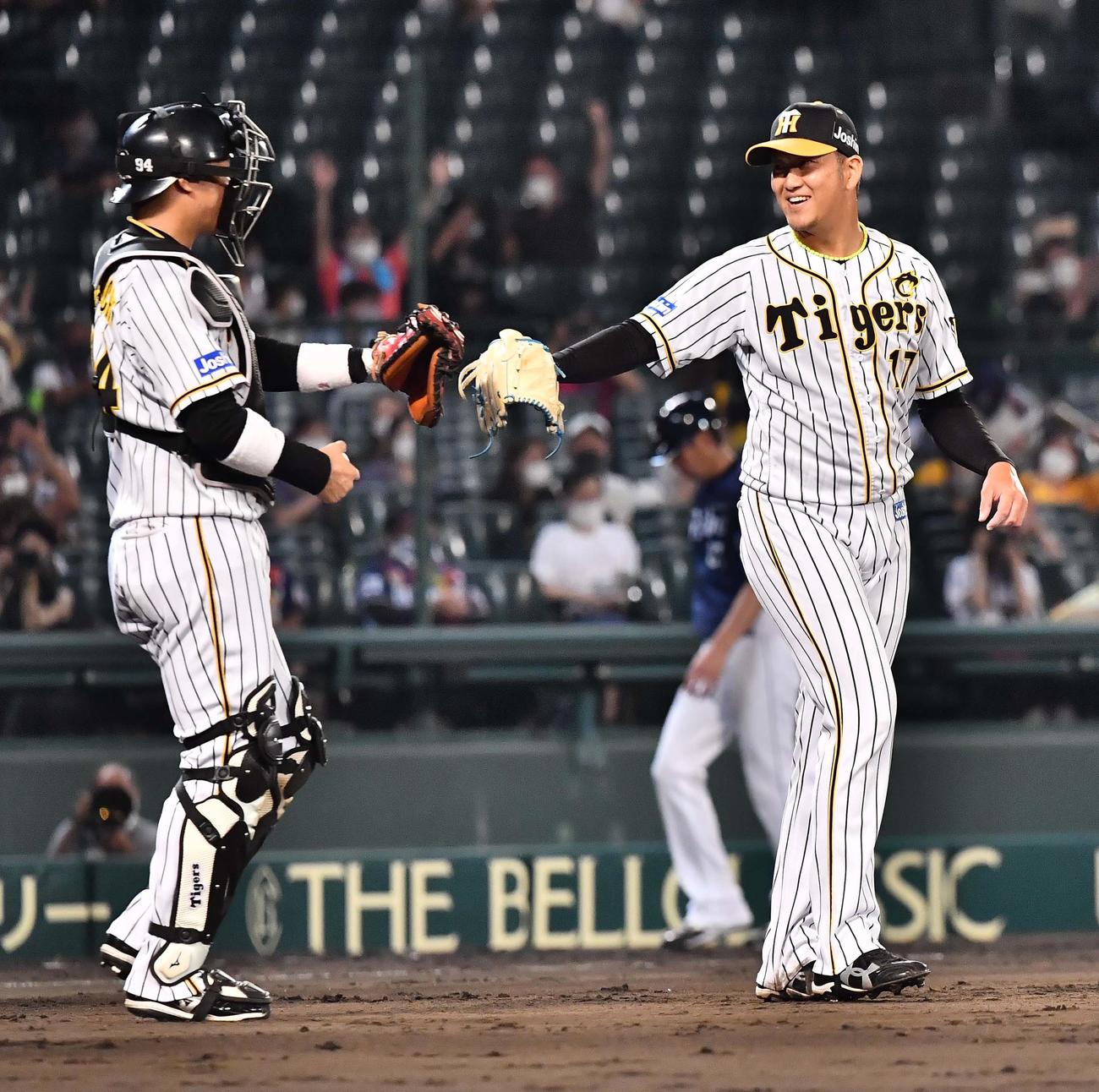 阪神対西武　西武に勝利し原口文仁（左）と笑顔でグラブタッチする岩貞（撮影・上田博志）
