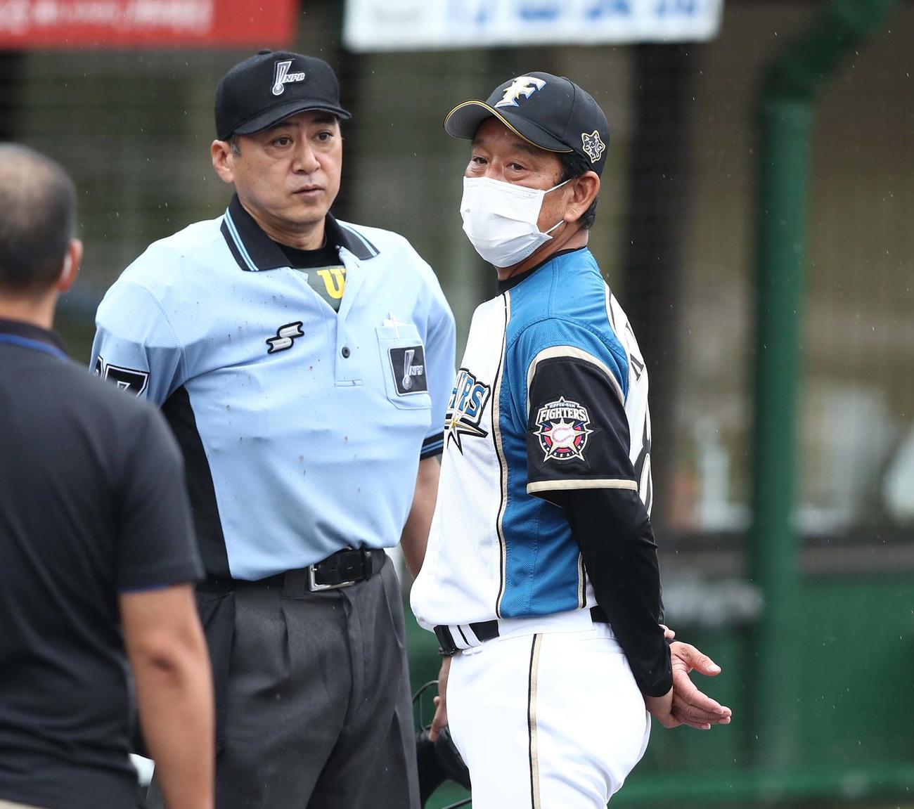 日本ハム対巨人　雨が強くなり審判と話す栗山監督（撮影・黒川智章）