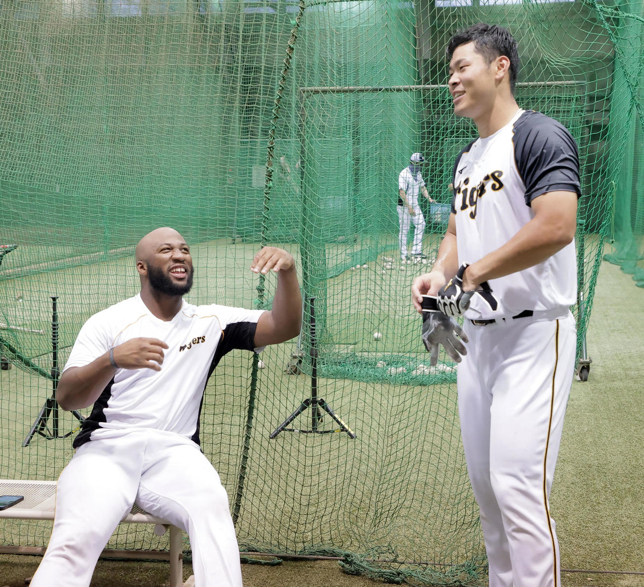 笑顔で話すロハス（左）と佐藤輝（球団提供）