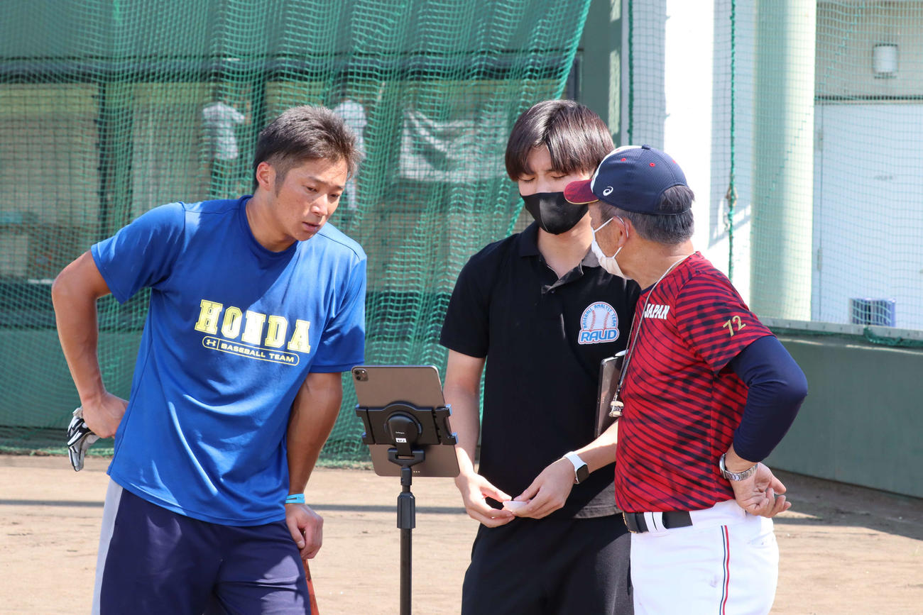 打撃練習後、自身の打撃データを入念にチェックする辻野雄大捕手（左）（撮影・阿部泰斉）