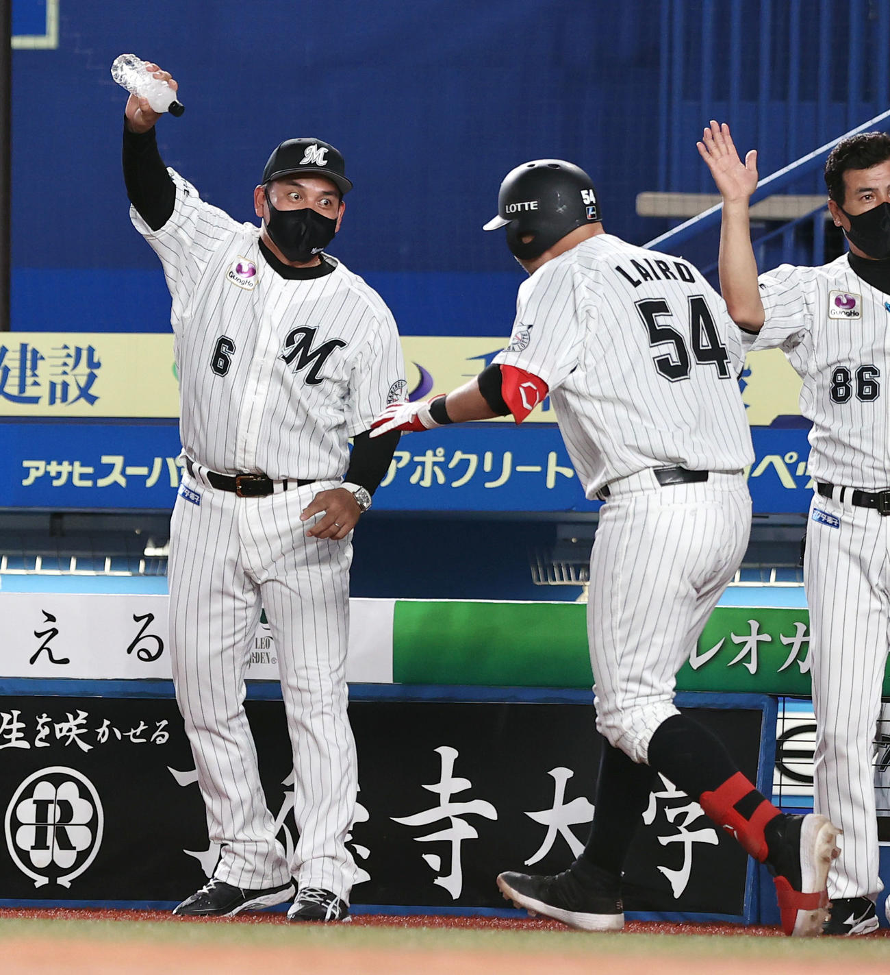 ロッテ対ヤクルト　9回裏ロッテ1死一、三塁、逆転サヨナラ3点本塁打を放ったブランドン・レアード（54番）に目を見開き水をかけるふりをする井口資仁監督（左）（撮影・垰建太）