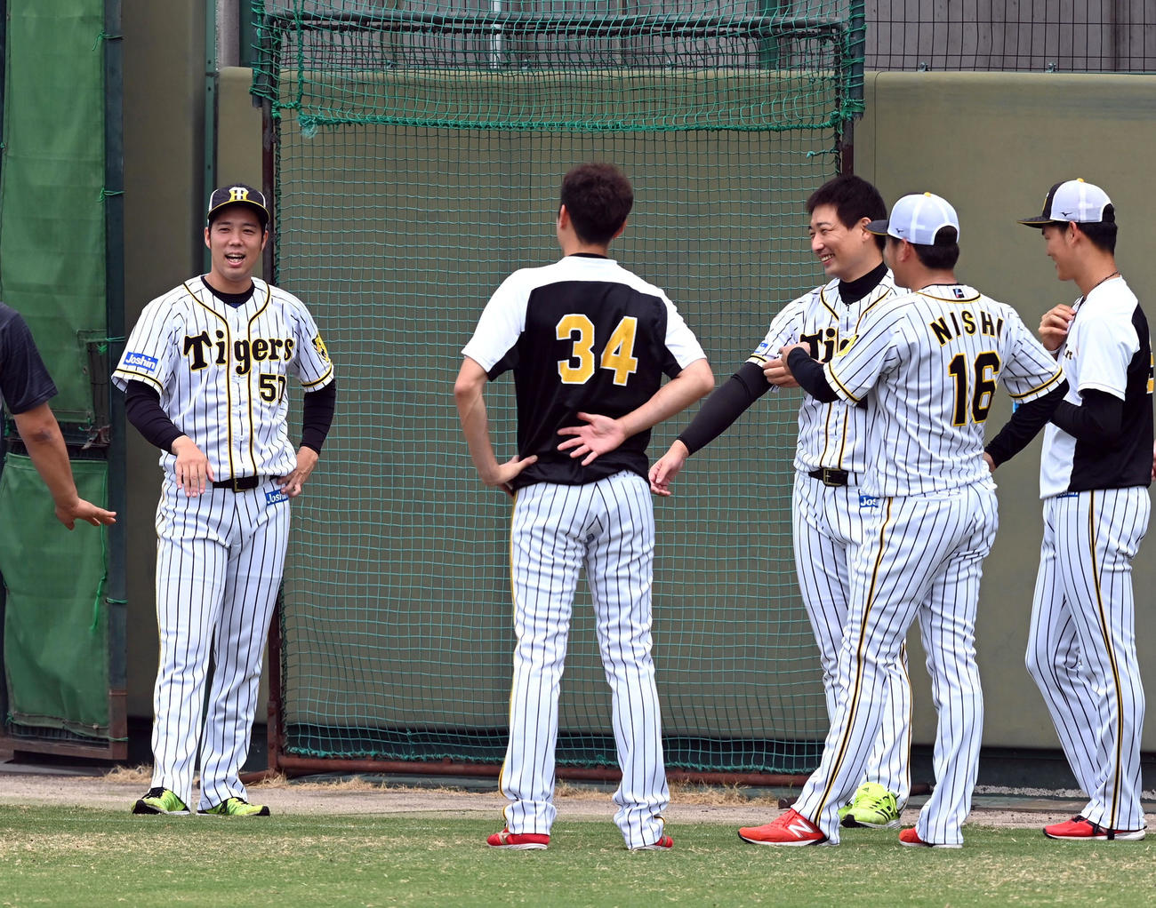 東京五輪を終えてチームに合流した青柳（左）と岩崎（同3人目）はナインに迎えられて笑顔を見せる（代表撮影）