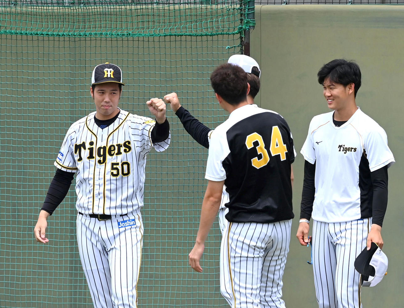 東京五輪を終えてチームに合流した阪神青柳（左）は投手陣とグータッチ（代表撮影）